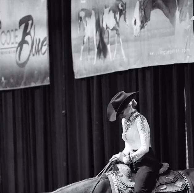 Black-and-white photograph of a western rider on horseback at a show